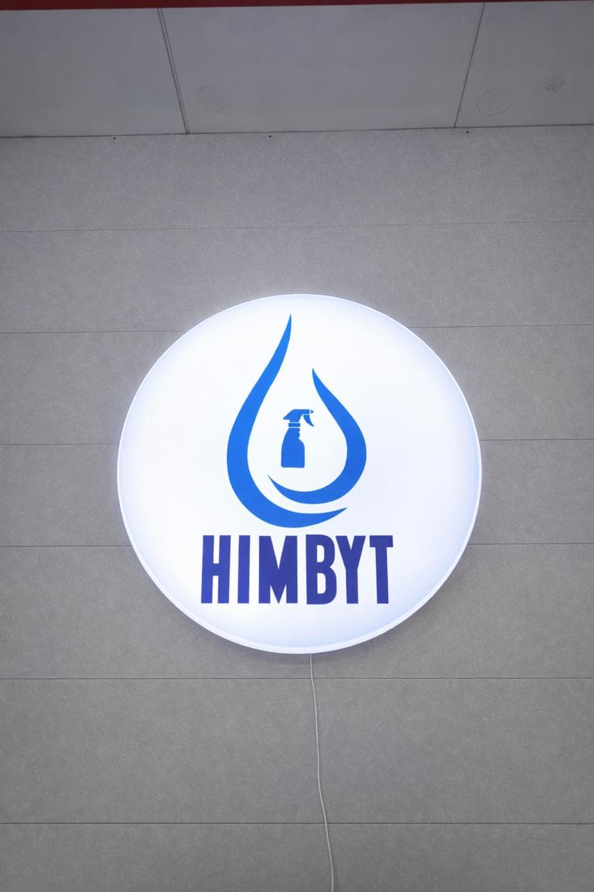 Круглая световая вывеска HIMBYT на фасаде